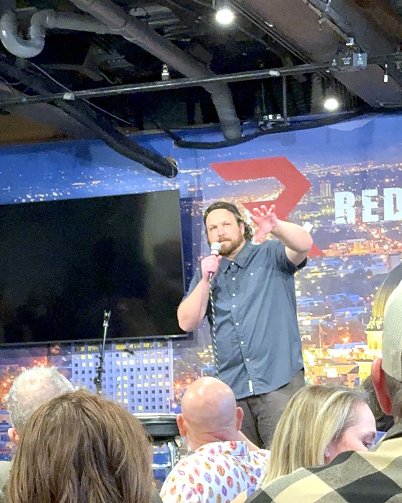 Jaron on stage at Redemption Bar & Grill, gesturing at the crowd
